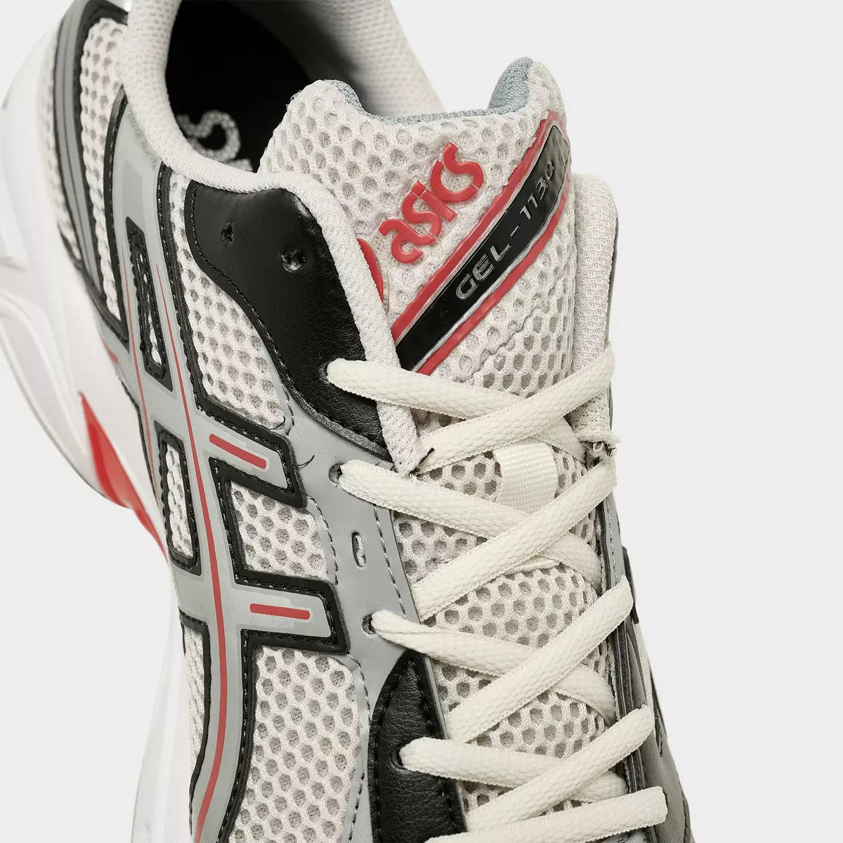ASICS GEL-1130 mesh sneaker in white, black, and red, close-up of lace and logo, footwear