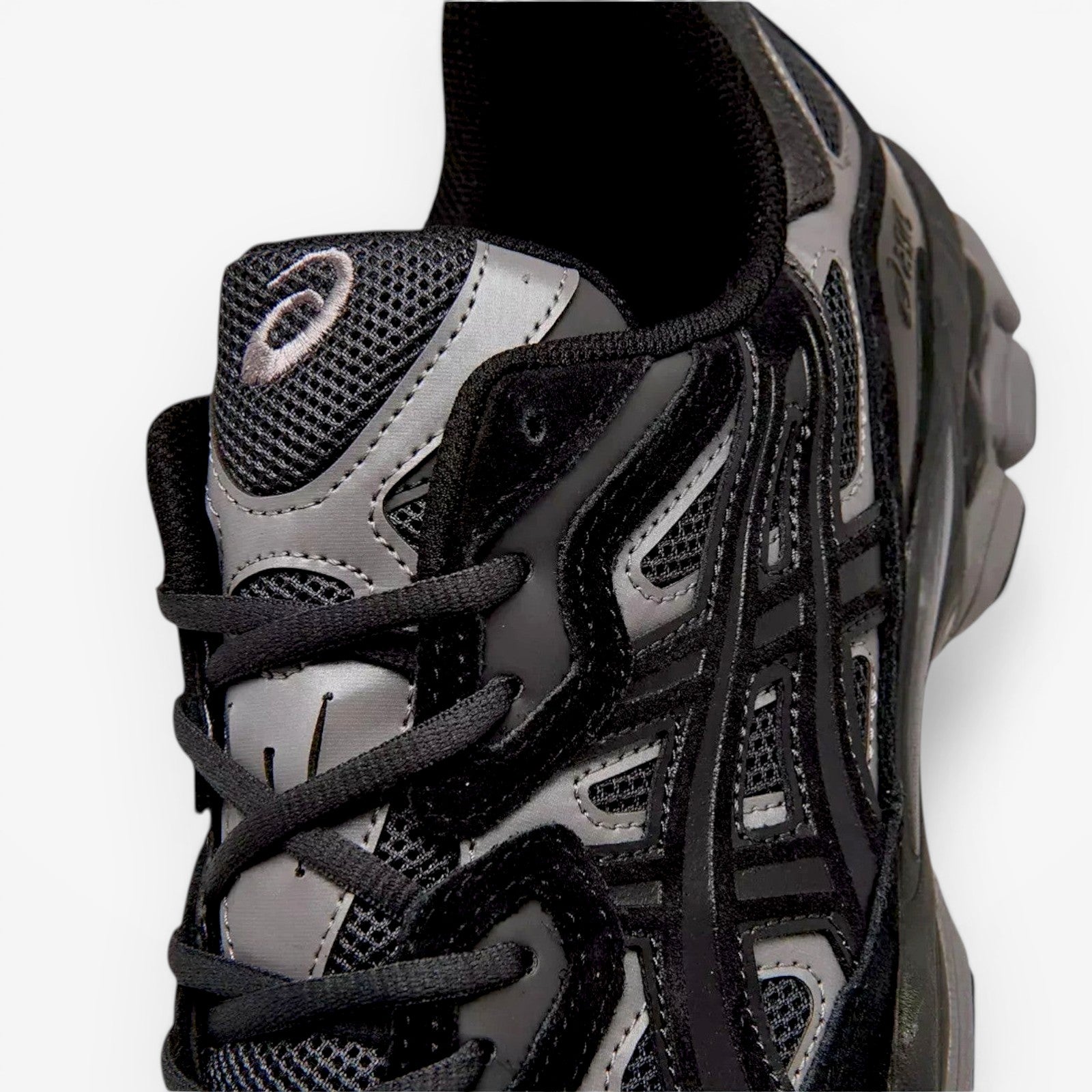 ASICS sneaker closeup showing black mesh and synthetic upper, part of athletic footwear collection