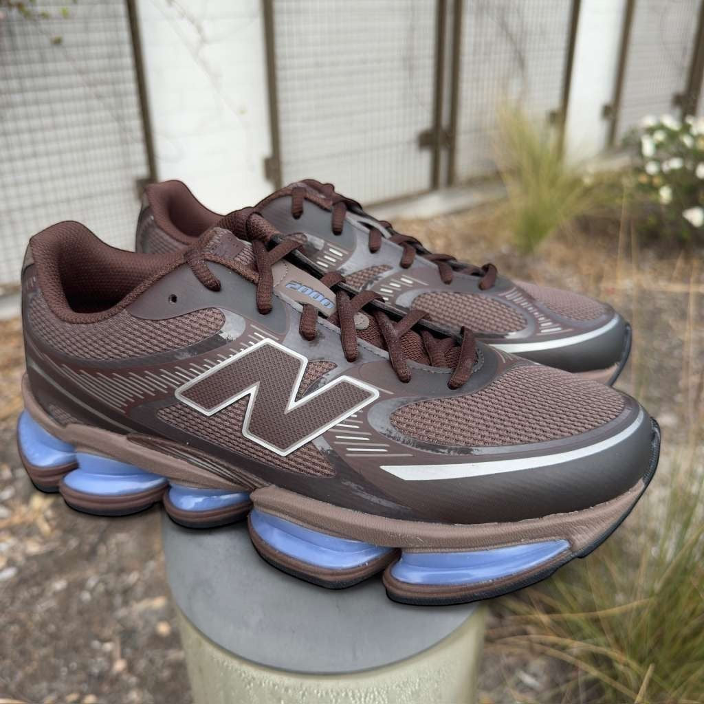 New Balance brown sneakers with blue sole detail, outdoor setting, new balance footwear
