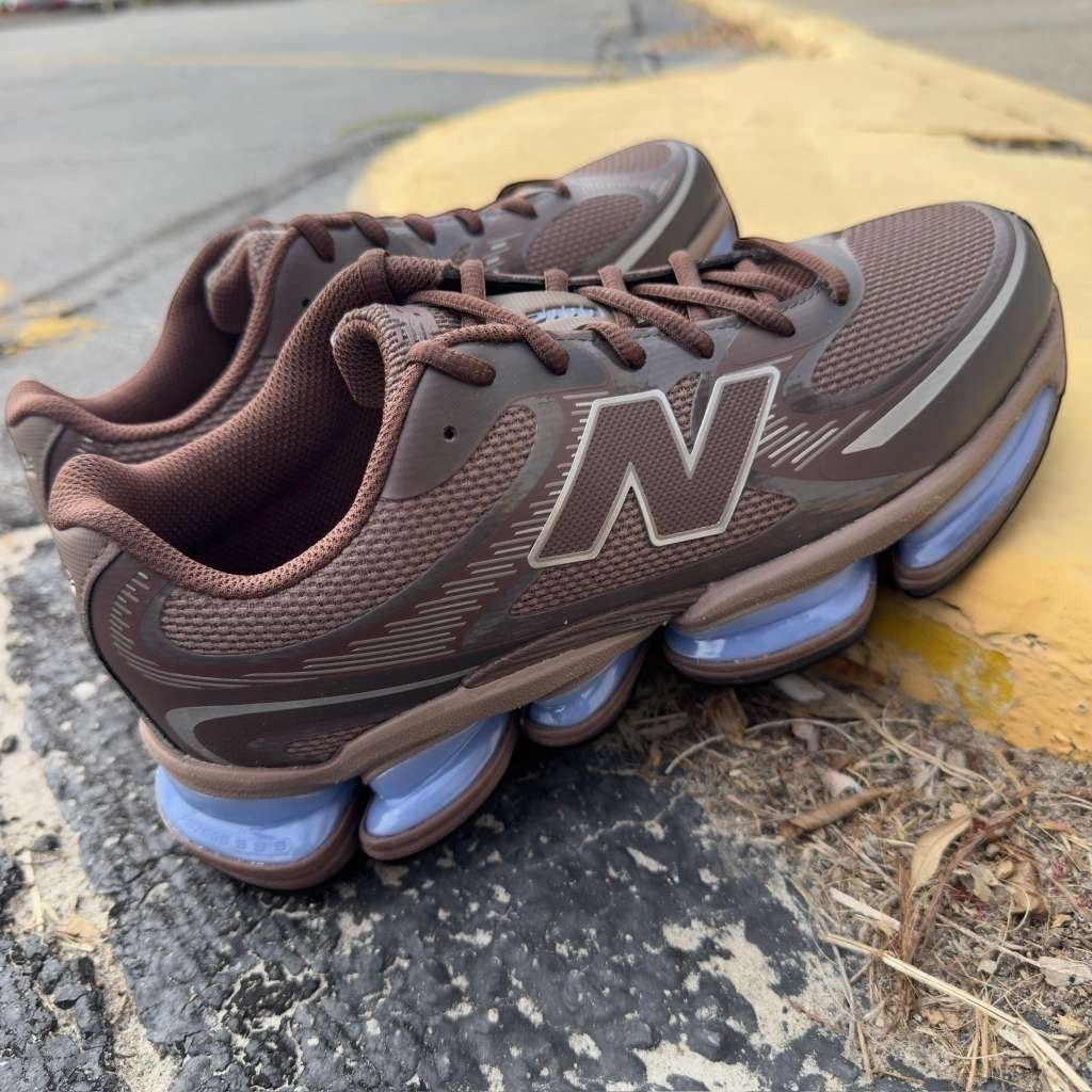 Brown New Balance sneakers with mesh upper and unique cushion soles on pavement