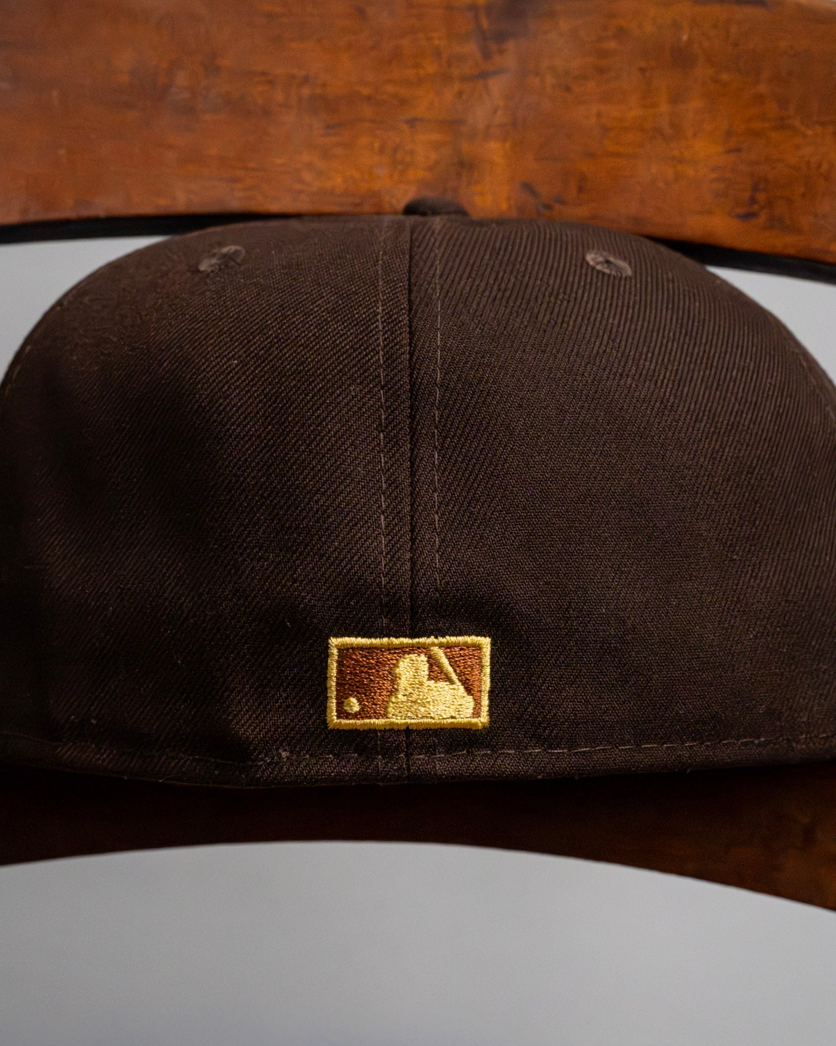 Brown New Era fitted cap with MLB logo, streetwear hats, closeup view