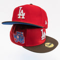 A red Los Angeles Dodgers 2022 World Series cap by New Era, featuring a brown visor, white embroidered 'LA' logo, and a blue and white '2022 World Series' patch on the front.