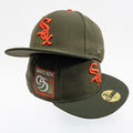 An olive green New Era White Sox 59FIFTY fitted cap with orange embroidered 'SOX' logos on the front and side, a white and orange White Sox patch on the side, and a gold size sticker on the brim, set against a plain white background.