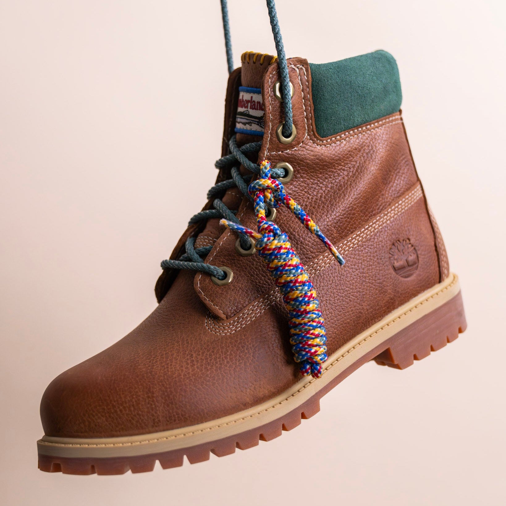 Brown leather boot with green suede collar, detailed laces, premium footwear, sneakers, timberland