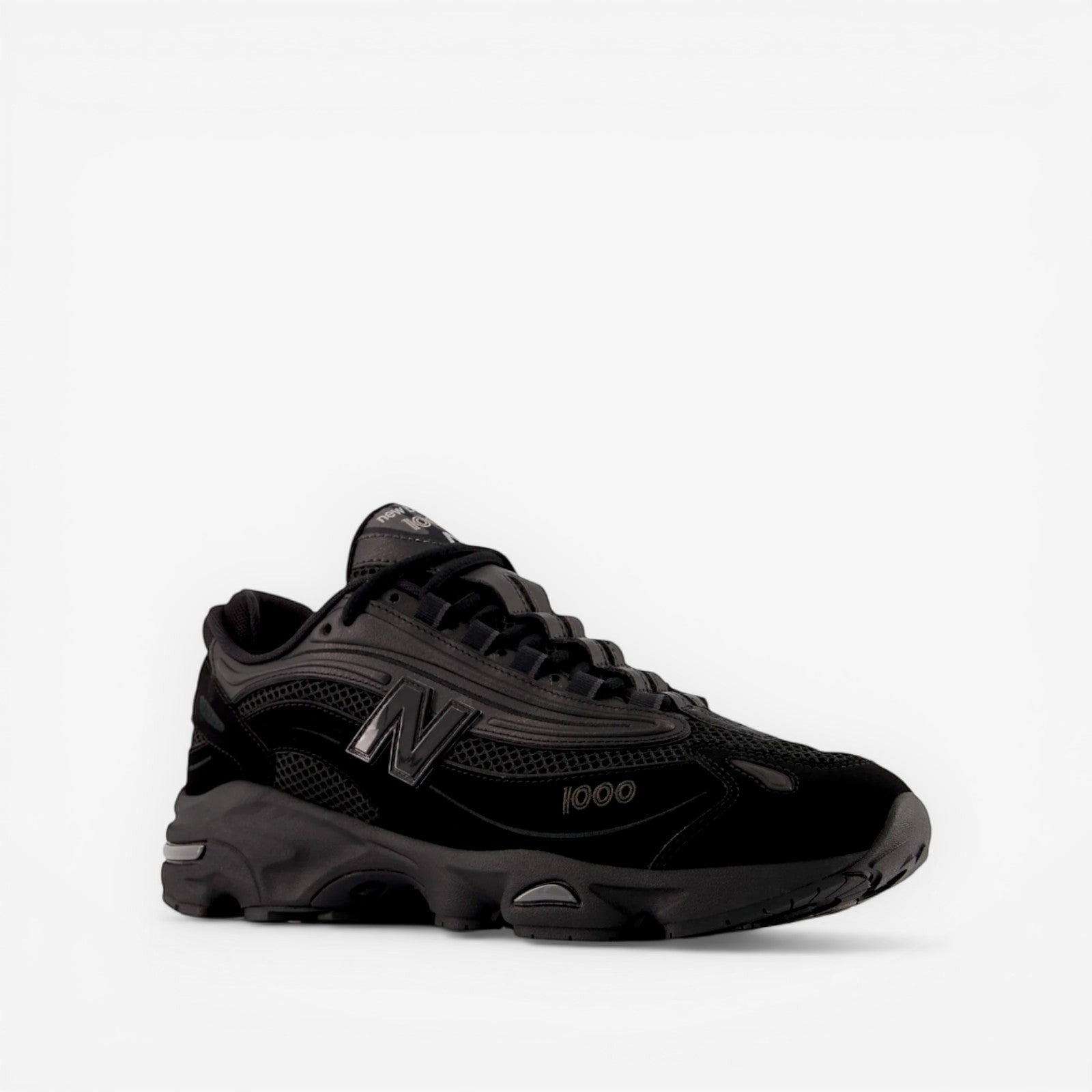 Black New Balance sneaker with mesh and suede details, side view, premium footwear