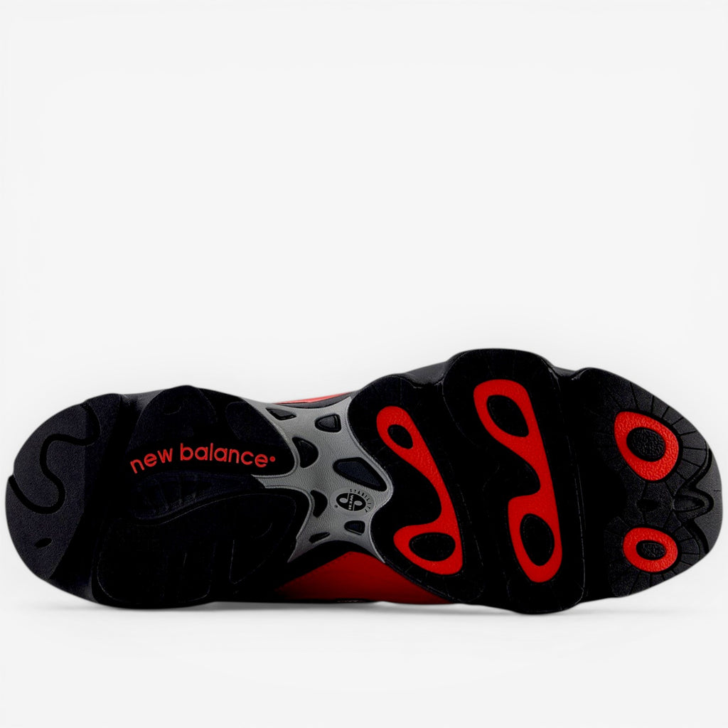 New Balance sneaker outsole in black, red, and gray with bold traction pattern, footwear