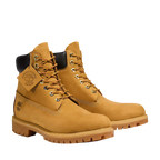 Pair of tan boots with a visible brand logo on a white background