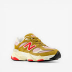 New Balance sneaker in tan, pink, and red with chunky sole, stylish footwear