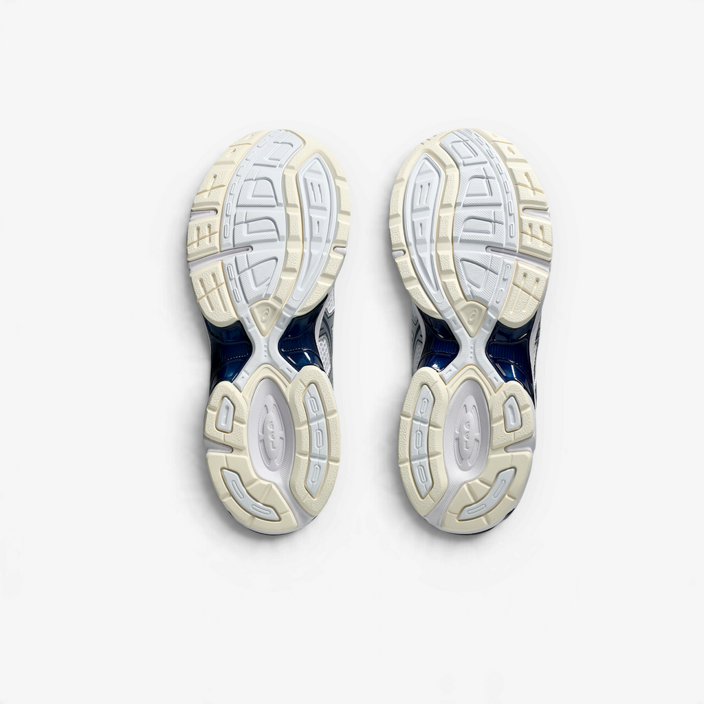METRO ASICS GEL-1130 retro running shoes in white and midnight blue, showing the durable rubber outsoles.