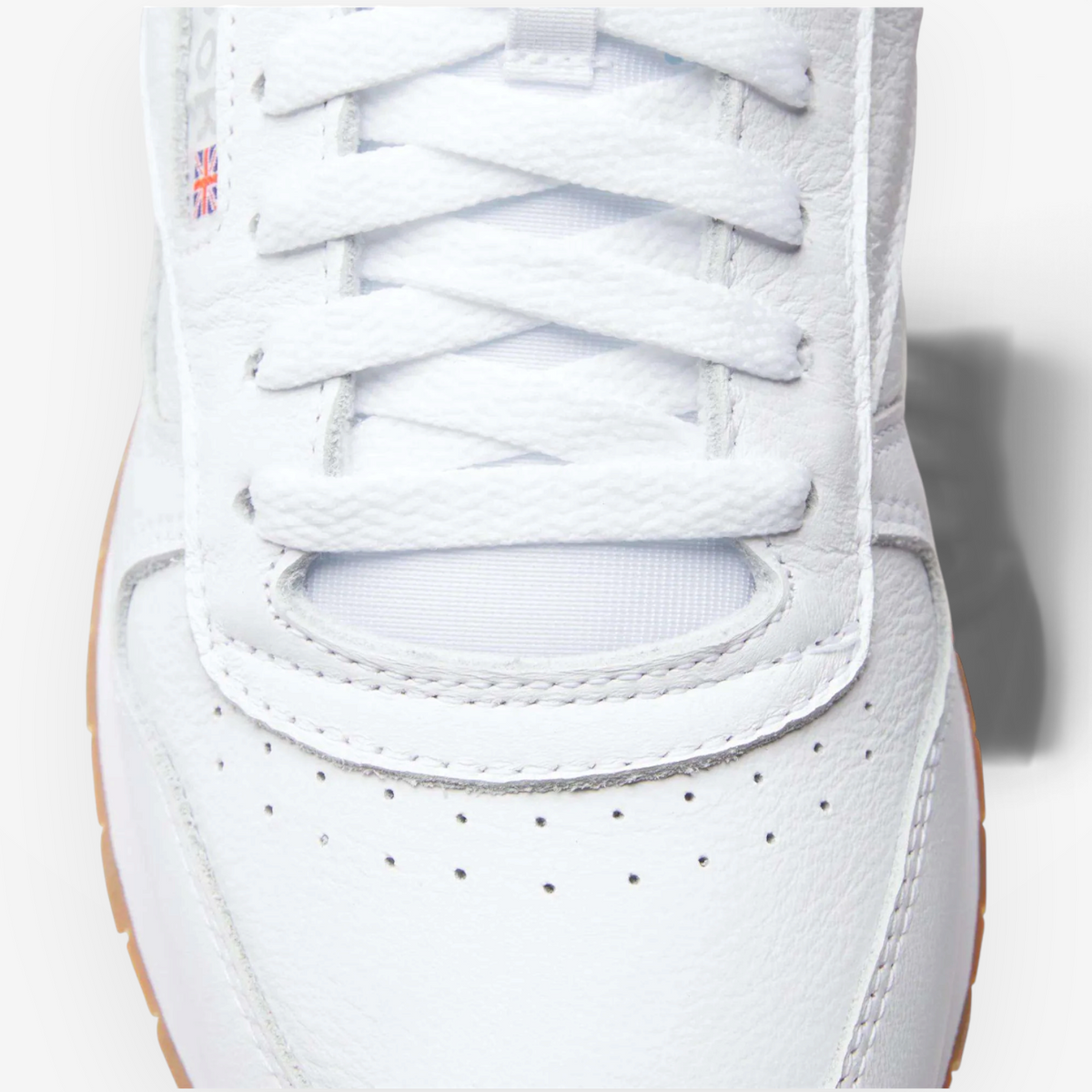METRO Reebok Classic Leather sneaker in white leather with grey accents and a gum sole, featuring a Union Jack logo.