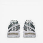 Back view of silver and white New Balance Asics sneakers, mesh and metallic detailing