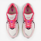 New Balance sneakers in pink, purple, and white with mesh and suede details, top view.