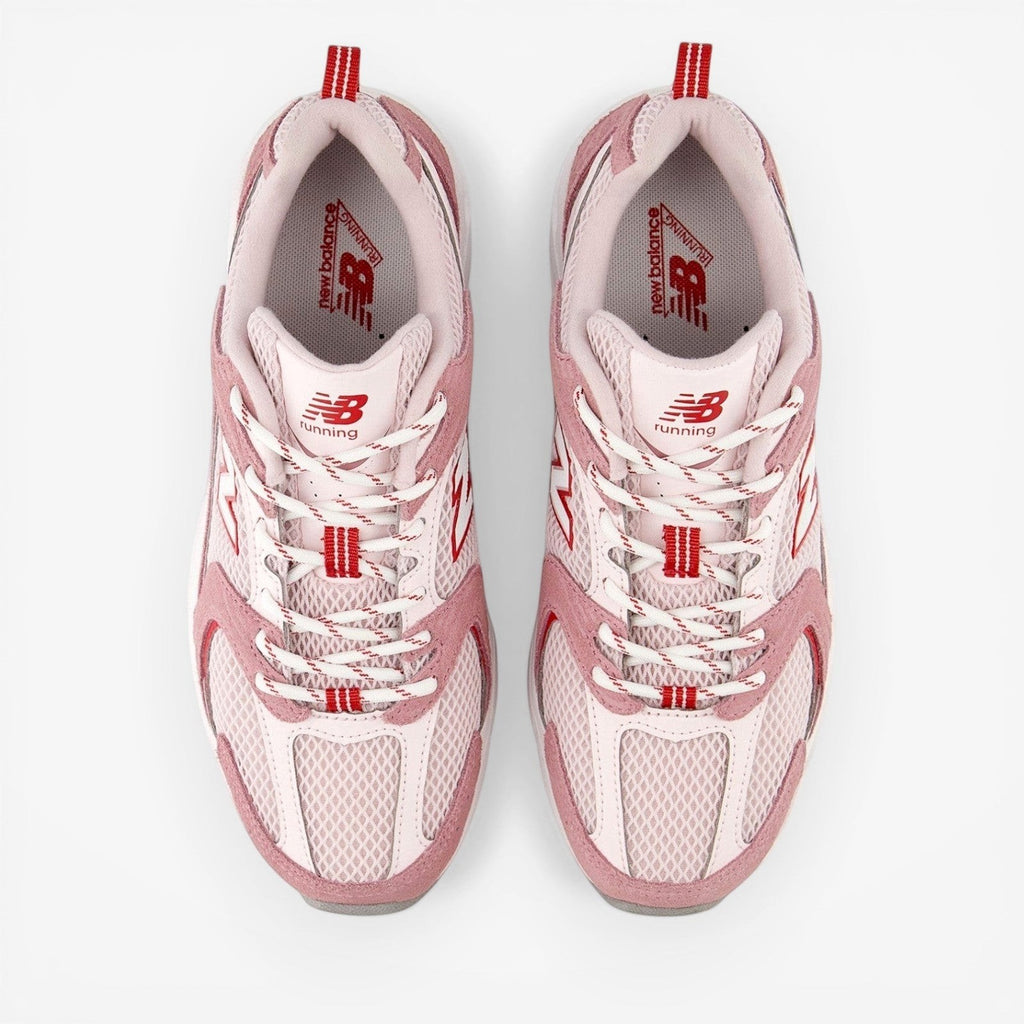 Pink and white New Balance sneakers with red accents, mesh and suede running shoes, top view