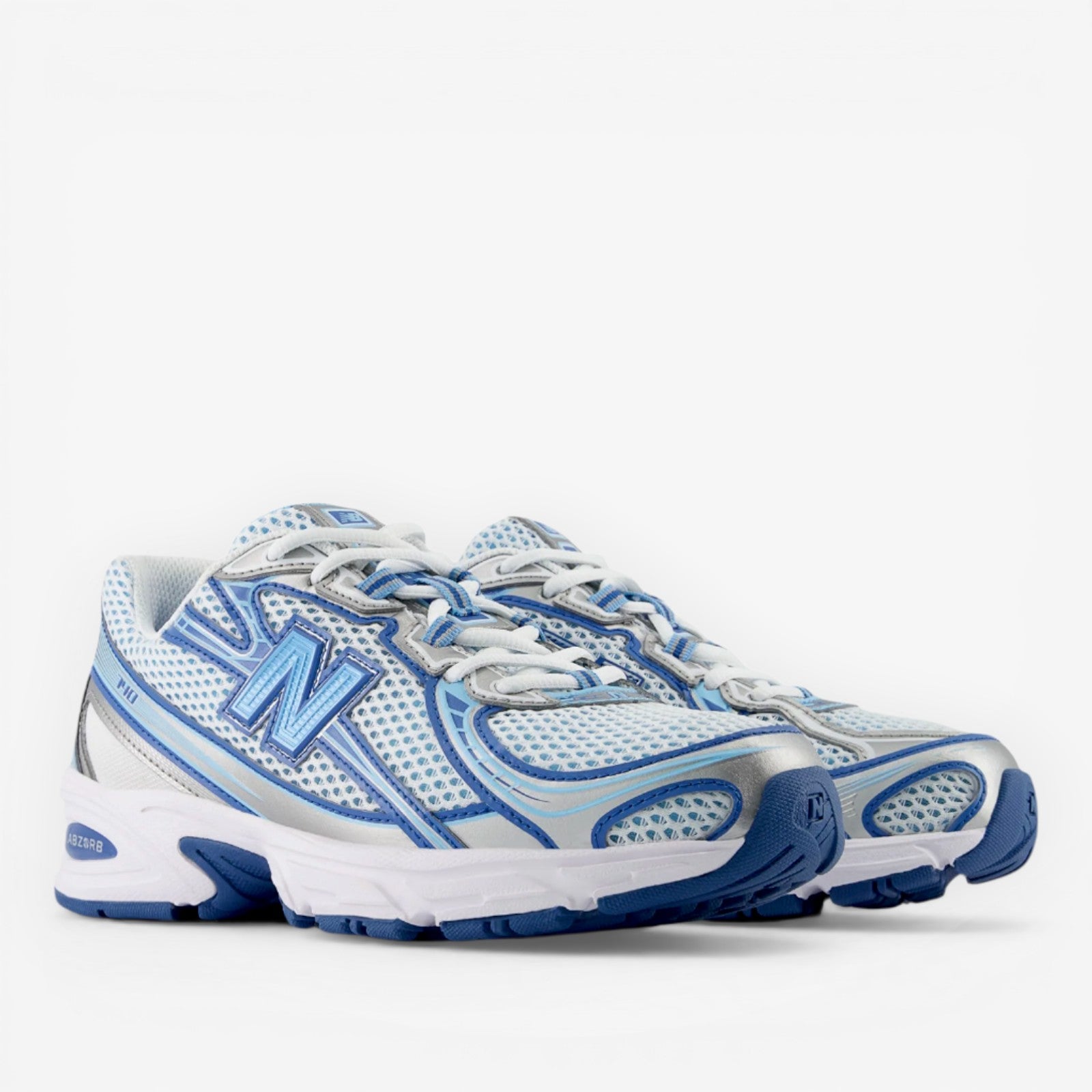 New Balance sneakers in white and blue with mesh and silver accents, athletic footwear