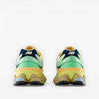 Rear view of New Balance sneakers in green, yellow, navy and tan, modern athletic footwear