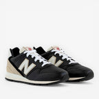 Black New Balance sneakers with white laces and beige accents, lifestyle footwear