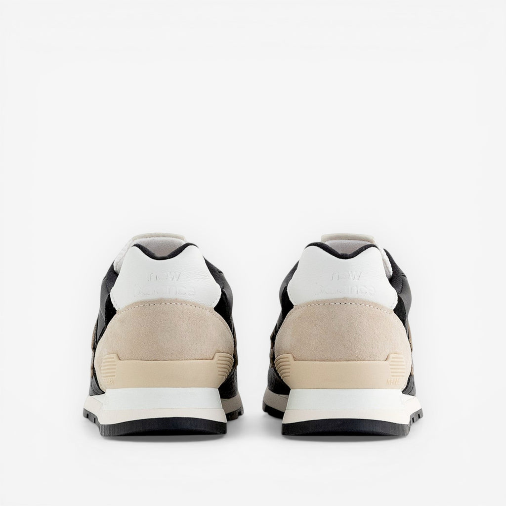 rear view of New Balance sneakers with beige suede and black leather accents, footwear