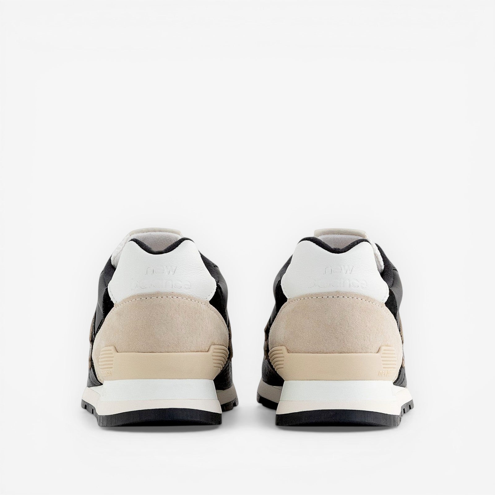 rear view of New Balance sneakers with beige suede and black leather accents, footwear