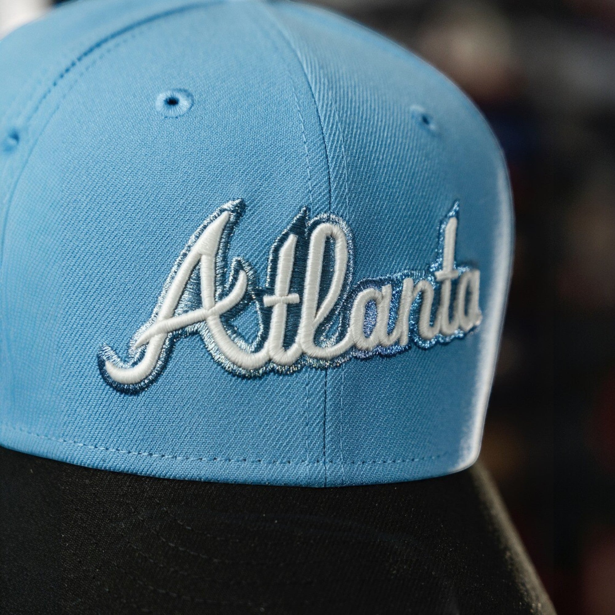 METRO Atlanta Braves blue fitted hat with white embroidered 'Atlanta' script and grey UV underbrim. New Era 59FIFTY silhouette.