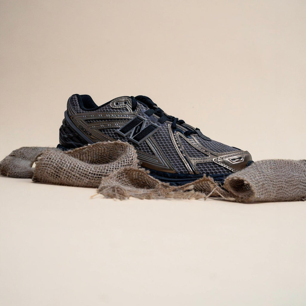 METRO New Balance 1906R sneaker in black and bronze with mesh and suede upper on a neutral background.