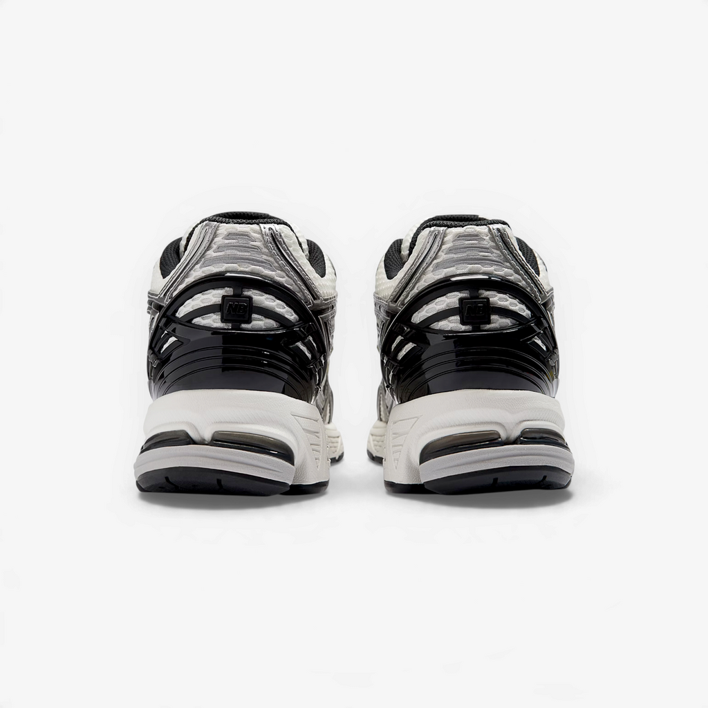 METRO New Balance 1906R retro runners in silver metallic and white, showing the structured TPU heel cage from behind.