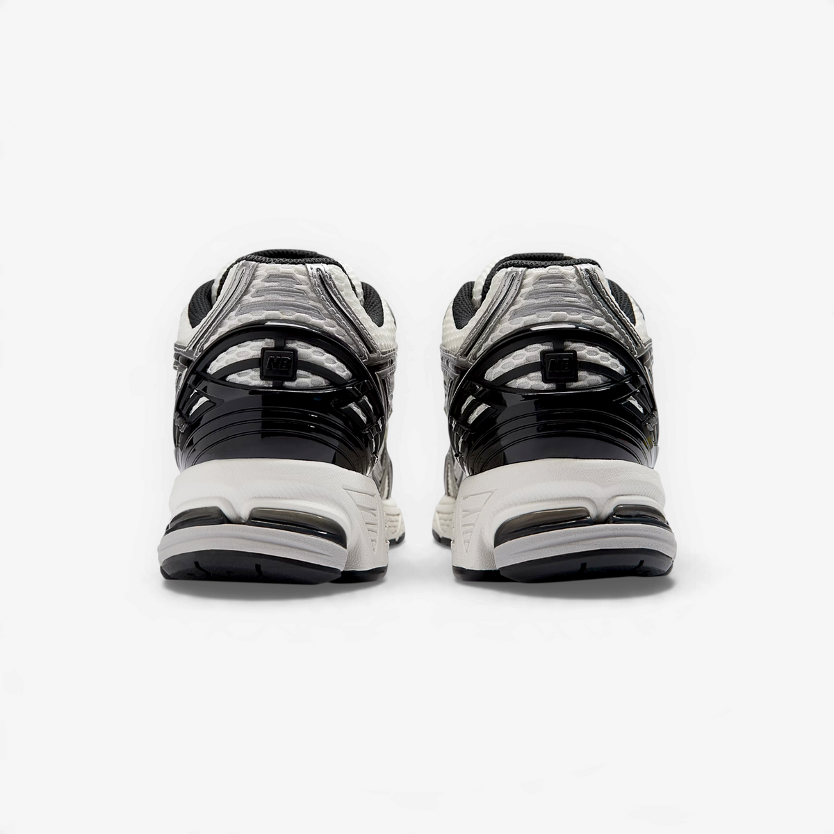METRO New Balance 1906R retro runners in silver metallic and white, showing the structured TPU heel cage from behind.