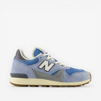 Light blue and grey New Balance sneaker with white laces on a black background, footwear