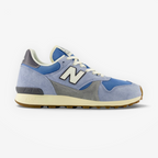 Light blue and grey New Balance sneaker with white laces on a black background, footwear