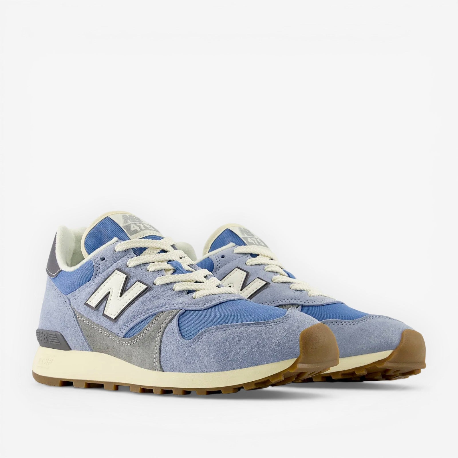 Light blue New Balance sneakers with suede and mesh upper, gum sole, and white laces