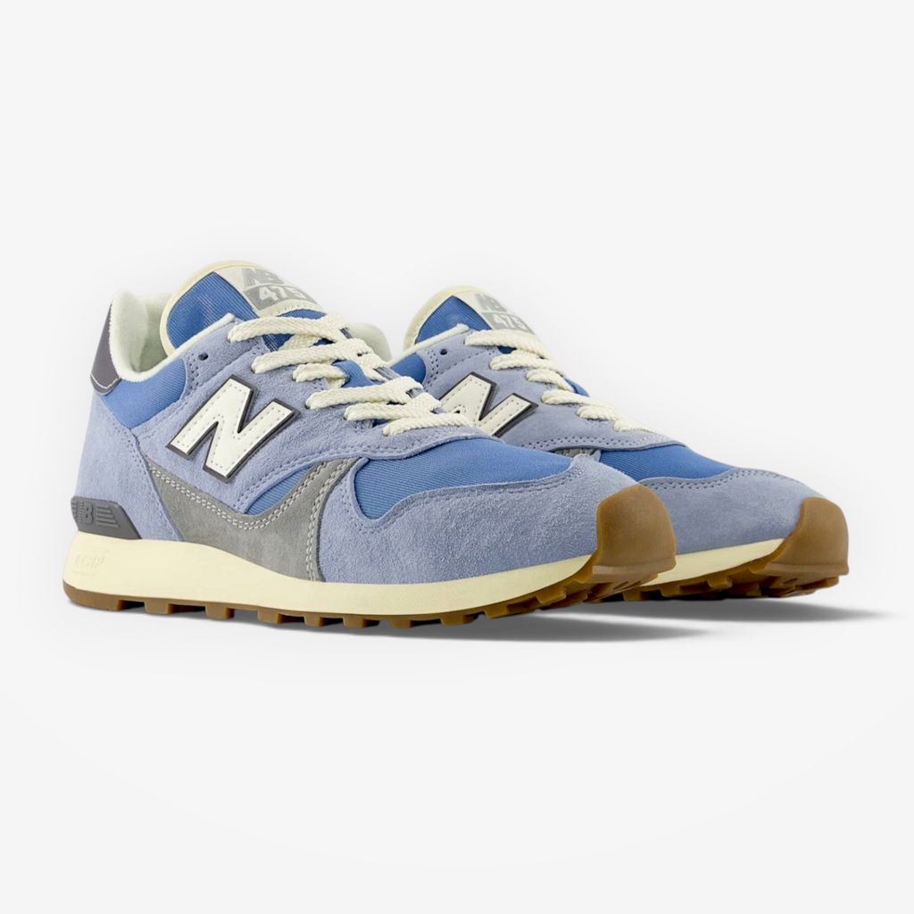 Light blue New Balance sneakers with suede and mesh upper, gum sole, and white laces