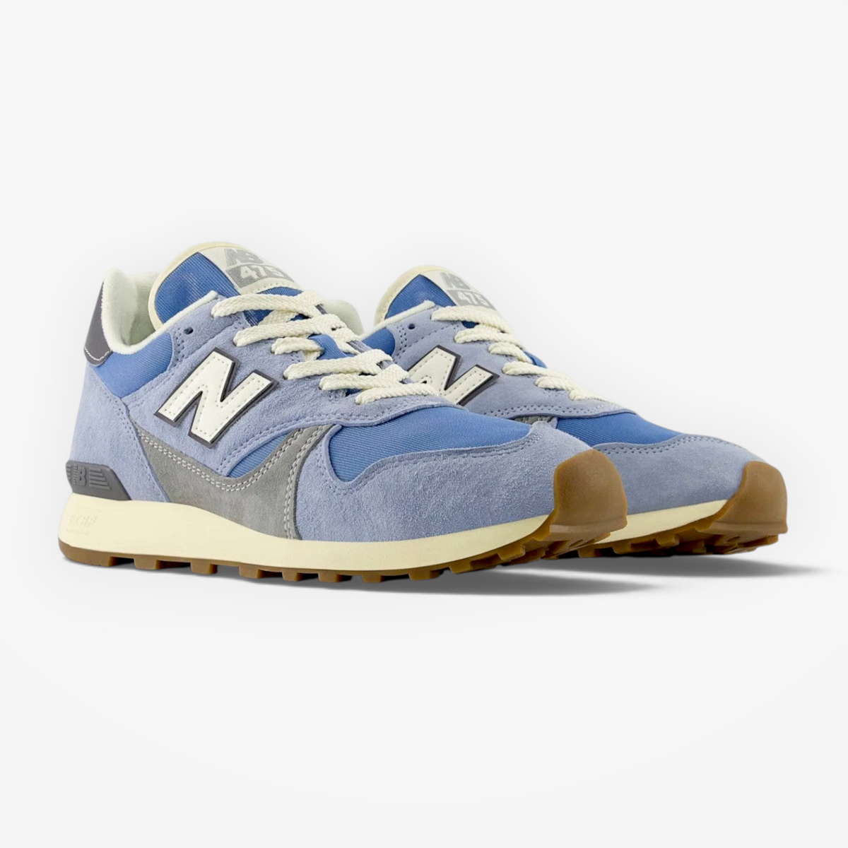 Light blue New Balance sneakers with suede and mesh upper, gum sole, and white laces