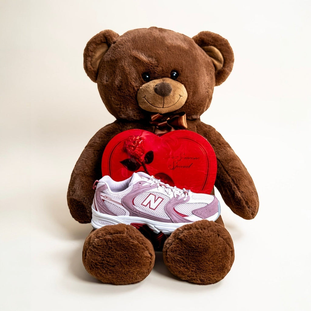 New Balance sneaker displayed on teddy bear with red heart-shaped box, footwear, sneakers