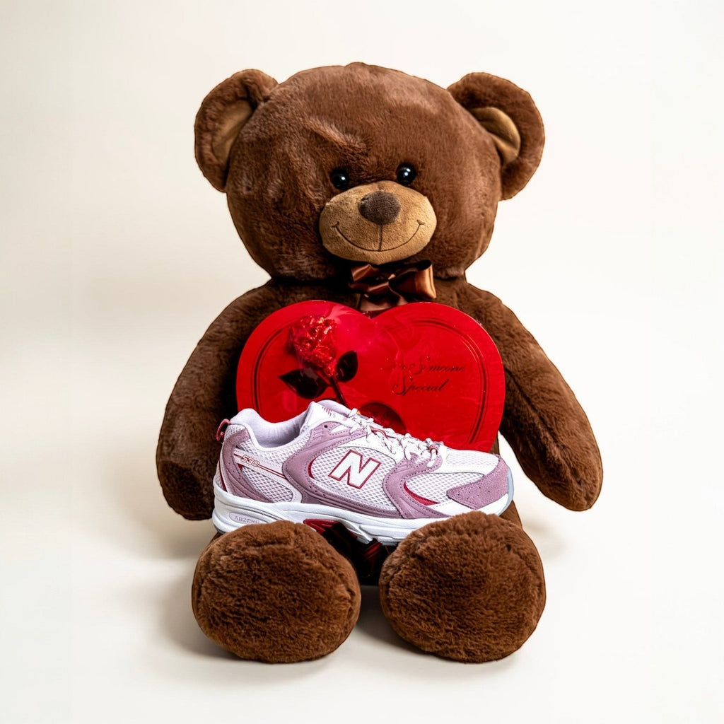 New Balance sneaker displayed on teddy bear with red heart-shaped box, footwear, sneakers
