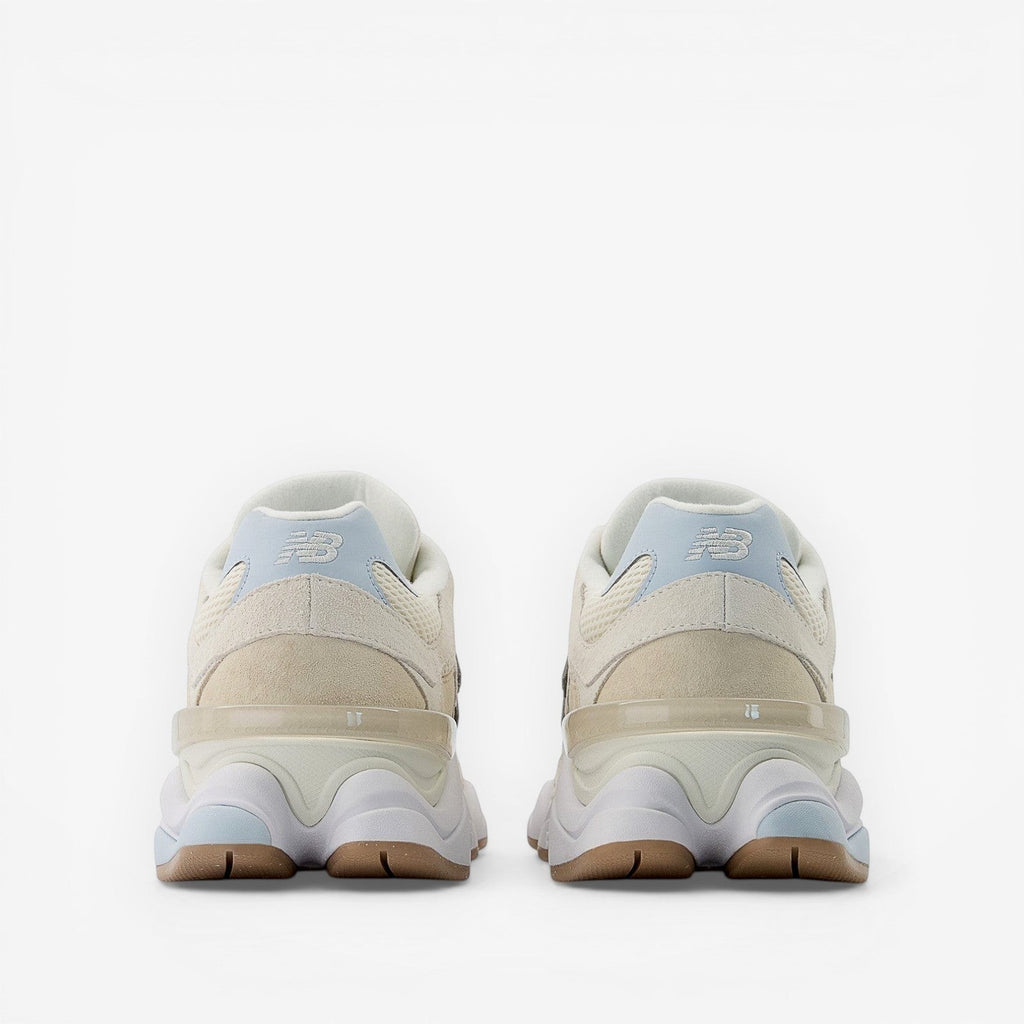 Beige New Balance sneakers viewed from the back, suede and mesh upper, rubber sole.