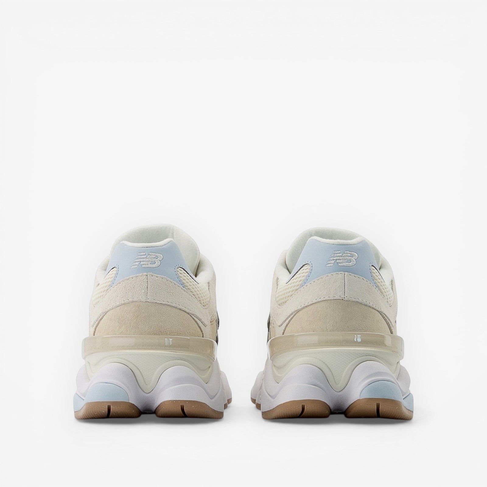 Beige New Balance sneakers viewed from the back, suede and mesh upper, rubber sole.