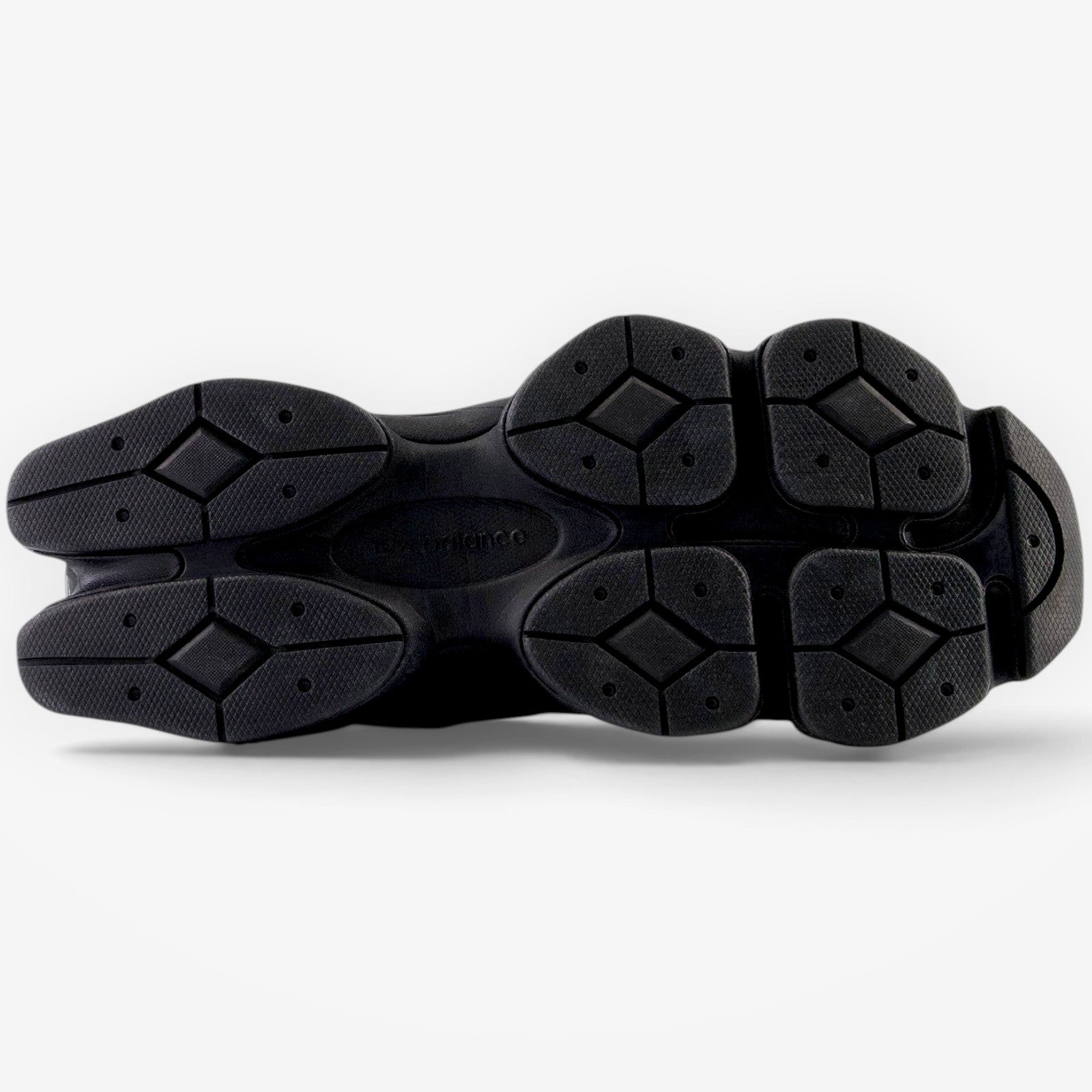 METRO New Balance 9060 Triple Black sneaker showing the detailed diamond-pattern rubber outsole design