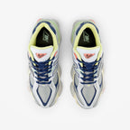 METRO New Balance 9060 Ice Blue sneakers featuring a layered mesh and suede upper with yellow and coral accents.