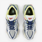 New Balance sneakers in blue, grey, and yellow with mesh upper, viewed from above