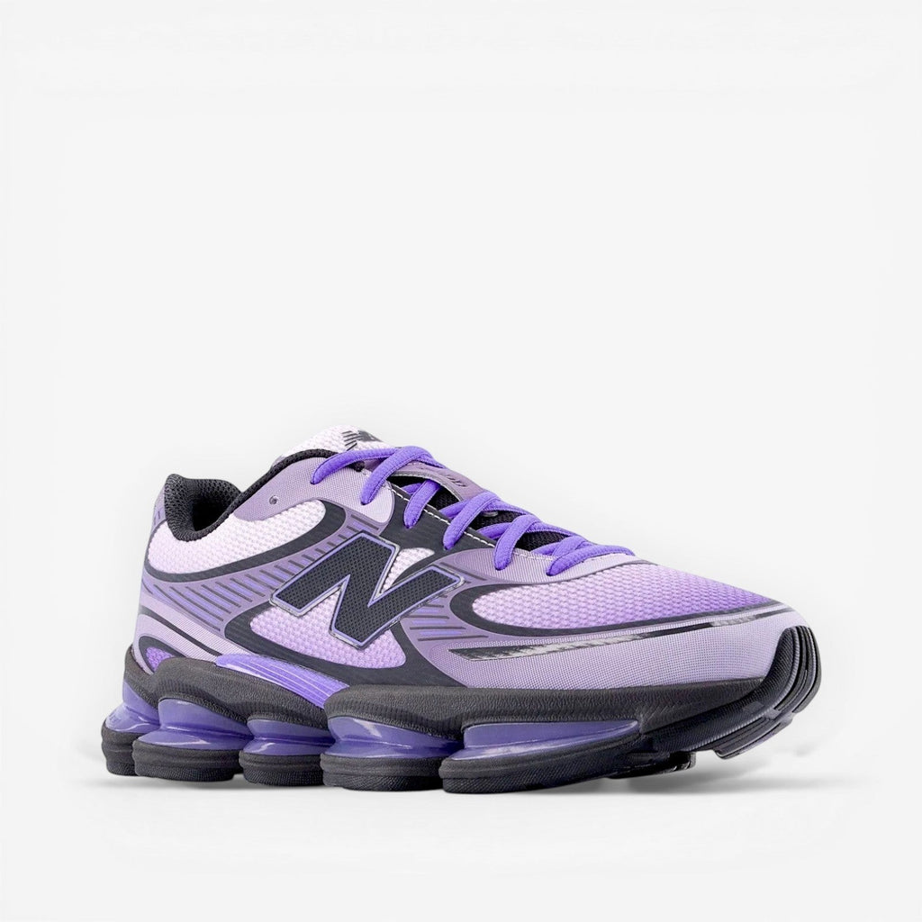 Purple New Balance sneaker with black and grey accents, athletic footwear on black background