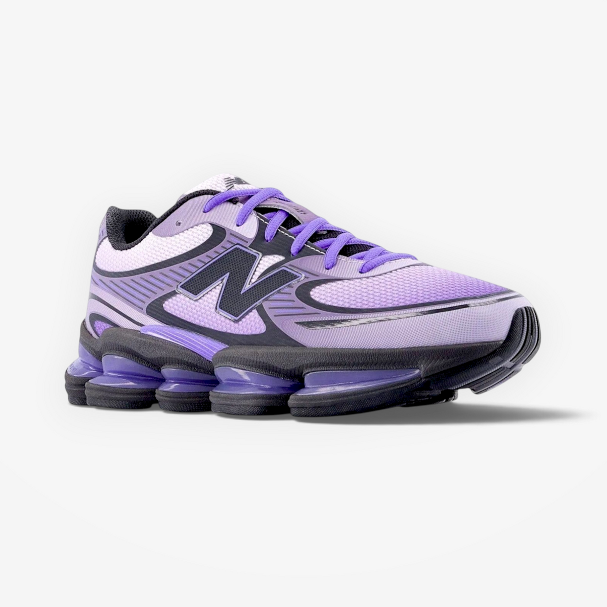 Purple New Balance sneaker with black and grey accents, athletic footwear on black background