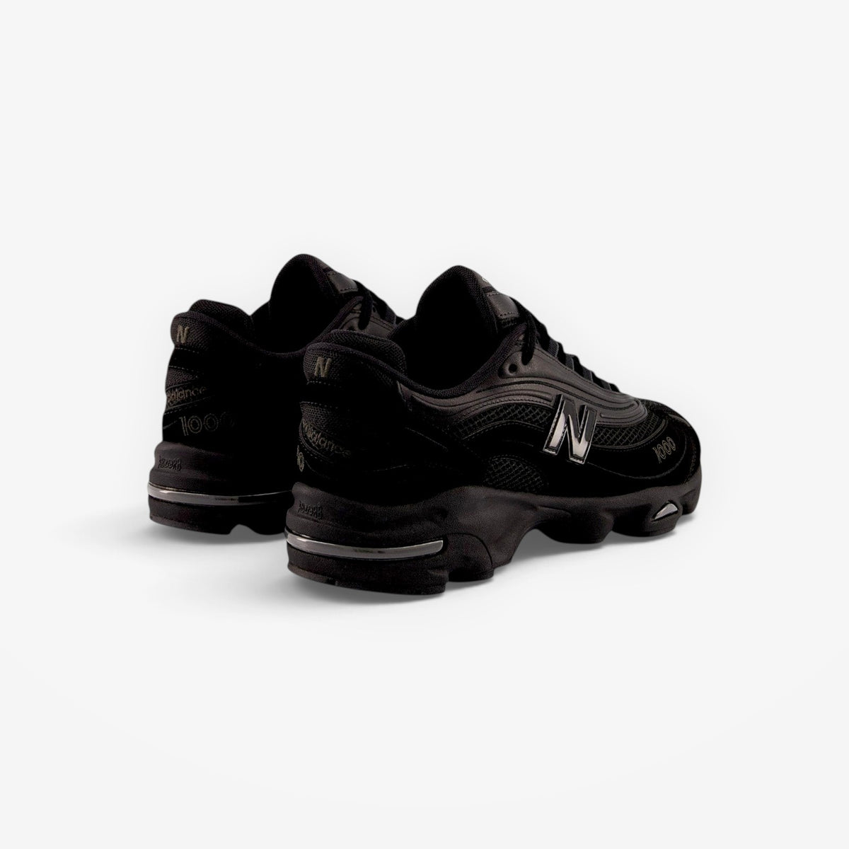 METRO New Balance M1000 black sneakers with mesh underlays, ABZORB cushioning, and sleek 1999-inspired design.