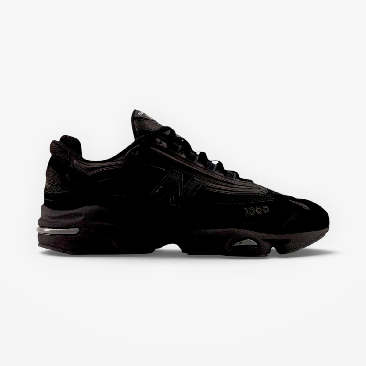 METRO New Balance M1000 black sneakers with mesh underlays, sleek overlays, and ABZORB cushioned segmented sole.