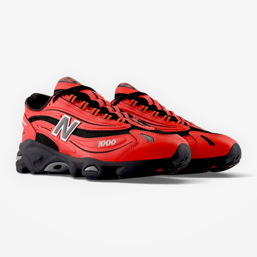 METRO New Balance M1000 sneakers in red and grey with mesh underlays, suede overlays, and ABZORB cushioning.