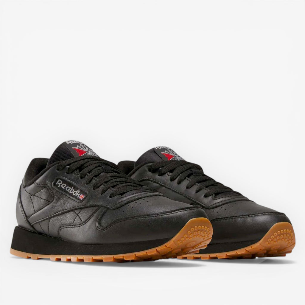 METRO Reebok Classic Leather black leather sneakers with grey accents and gum sole. Lace-up, low-top style.