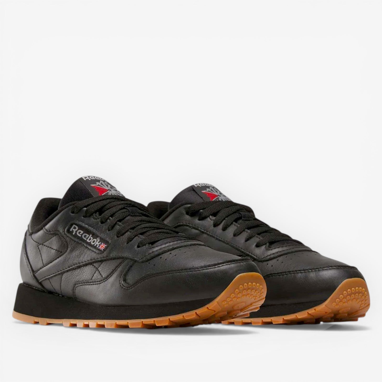 METRO Reebok Classic Leather black leather sneakers with grey accents and gum sole. Lace-up, low-top style.