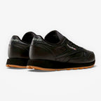 METRO Reebok Classic Leather black leather sneakers with grey accents and gum sole. Low-top lace-up style.