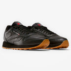 METRO Reebok Classic Leather black leather sneakers with grey accents and gum sole. Lace-up, low-top style.