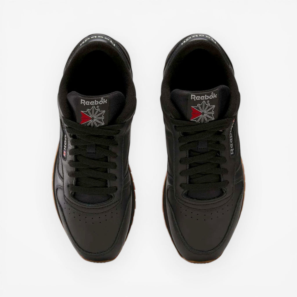 METRO Reebok Classic Leather black leather sneakers with grey accents and gum sole. Low-top lace-up style.