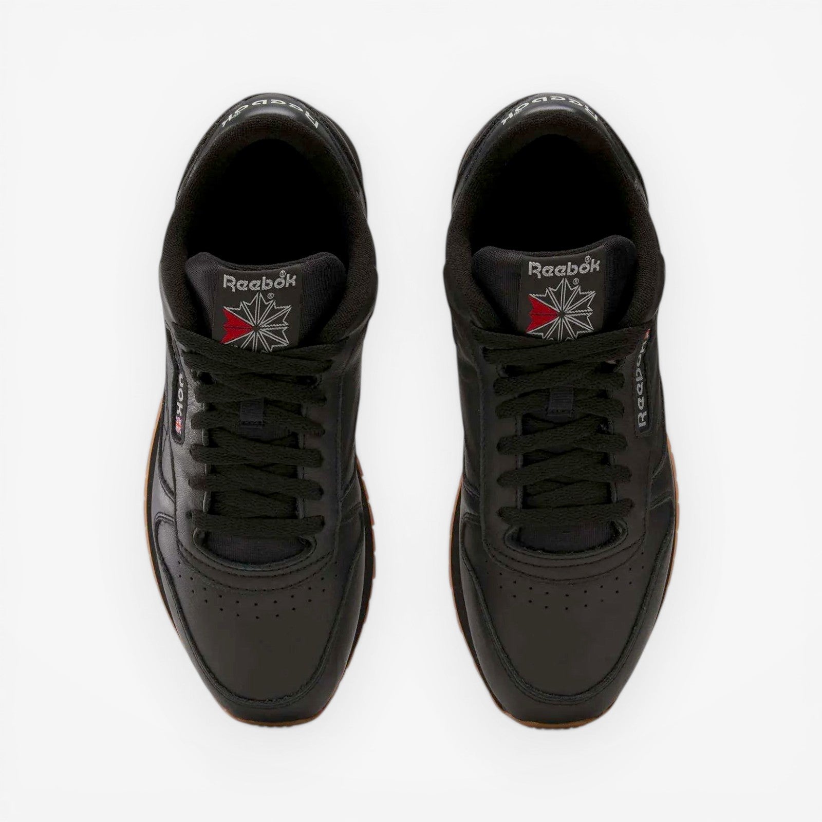 METRO Reebok Classic Leather black leather sneakers with grey accents and gum sole. Low-top lace-up style.