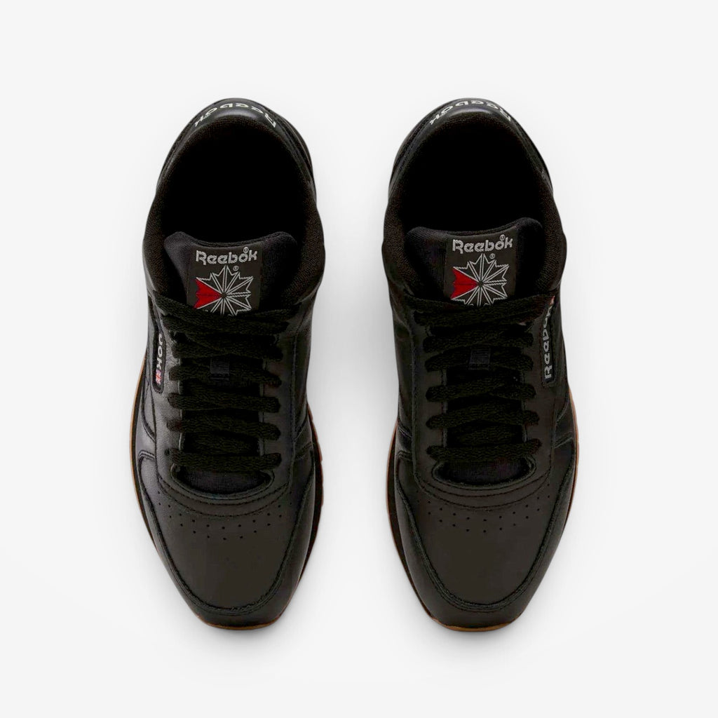 METRO Reebok Classic Leather black leather sneakers with grey accents and gum sole. Low-top lace-up style.